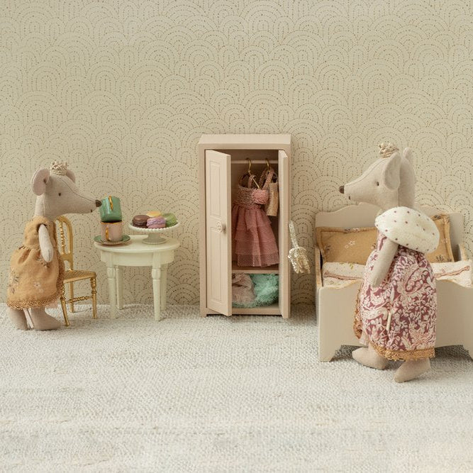 Miniature scene with toy mice in a room setting, including a wardrobe and furniture.
