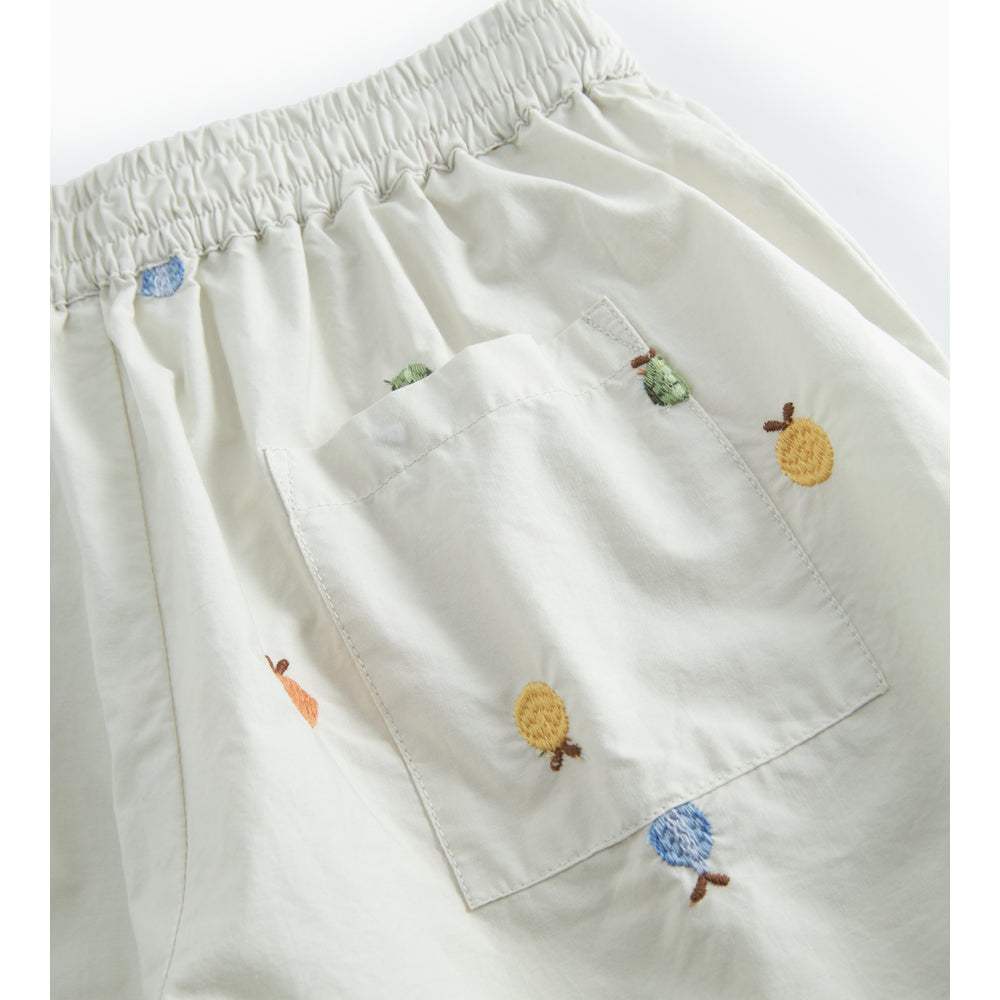 White shorts with colorful embroidered designs on a white background