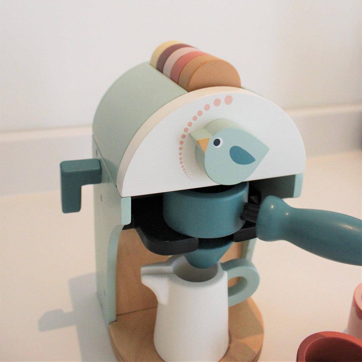 Children's toy coffee maker with a bird design on a light background