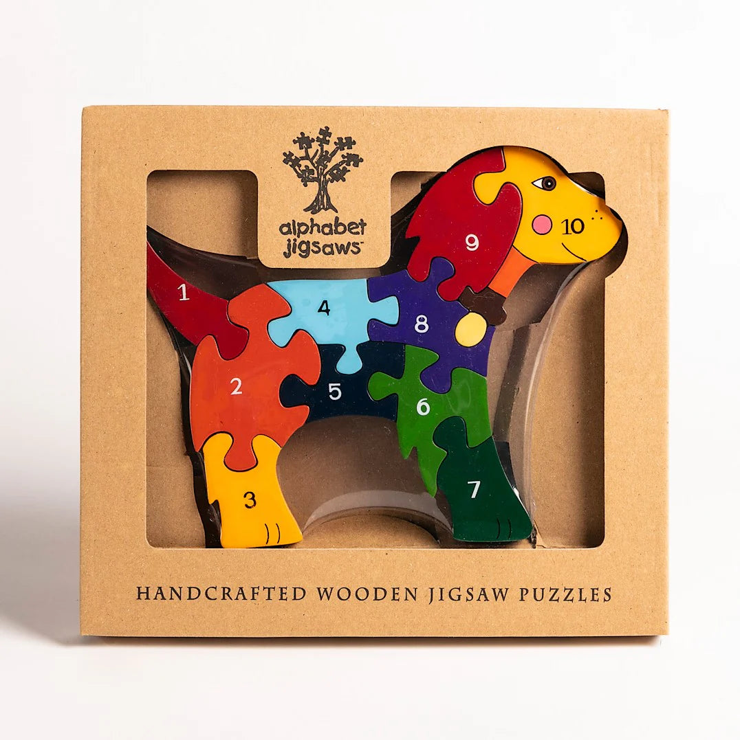 Handcrafted wooden jigsaw puzzle shaped like a cow with numbers on a cardboard box.