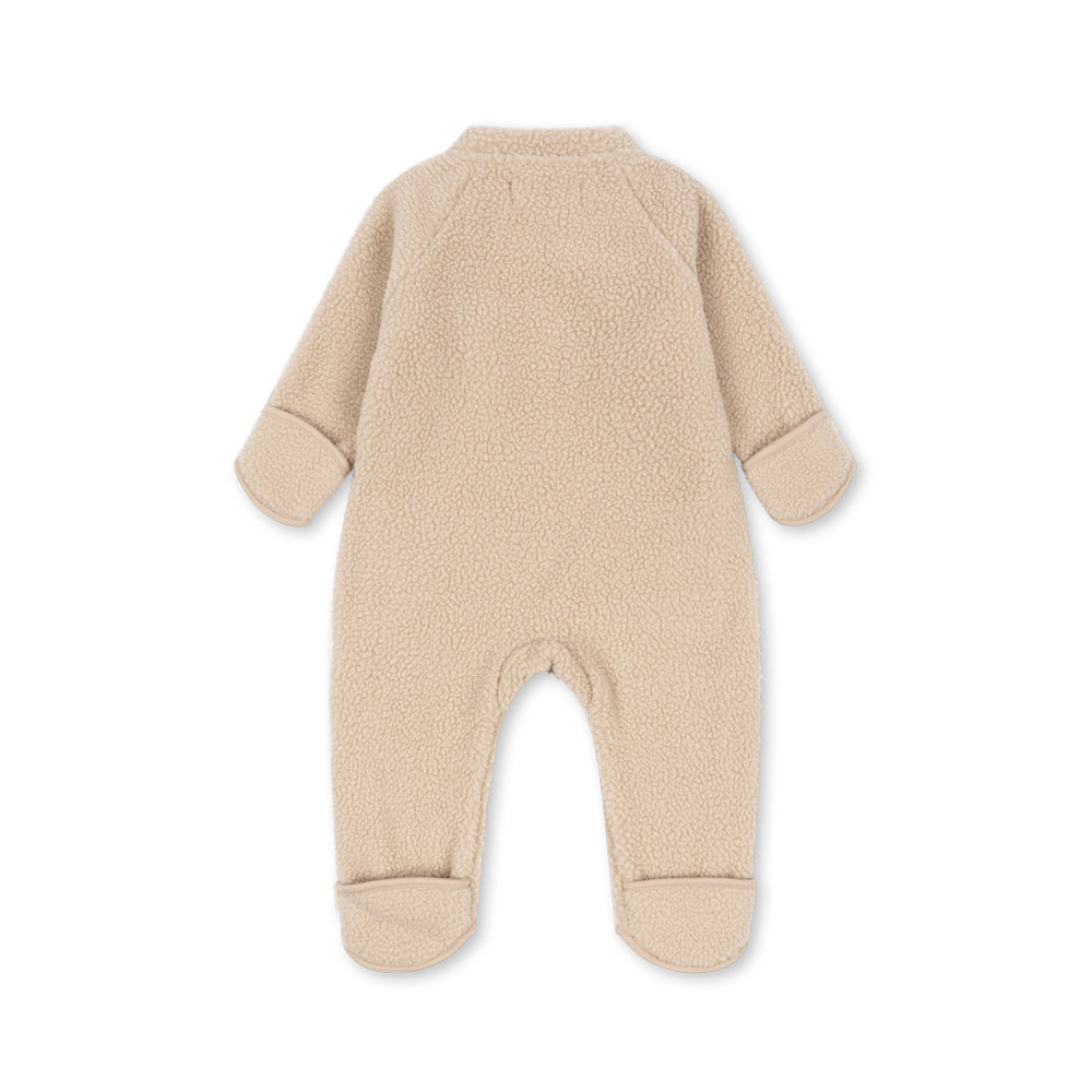 A light beige fleece footed one-piece baby jumpsuit shown from the back on a white background.