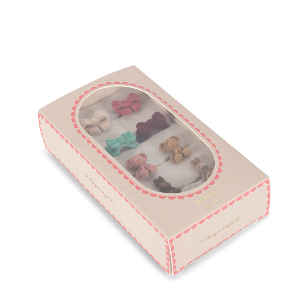 Set of colorful hair clips in a decorative box on a white background