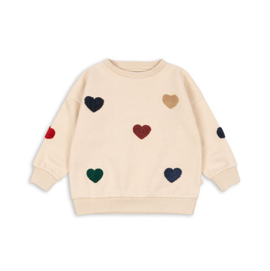 Beige sweater with colorful heart patterns on a white background