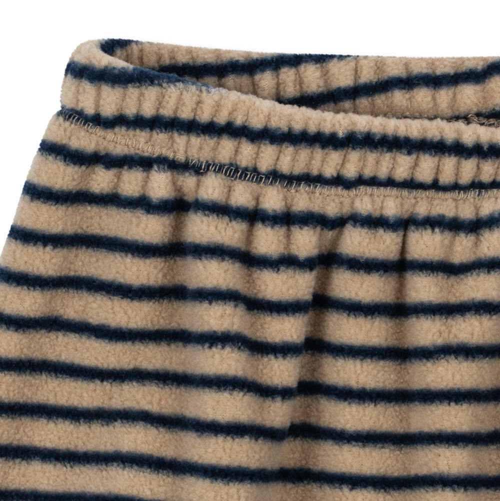 Close-up of a striped fleece garment, showing horizontal navy blue and beige stripes with an elastic waistband.