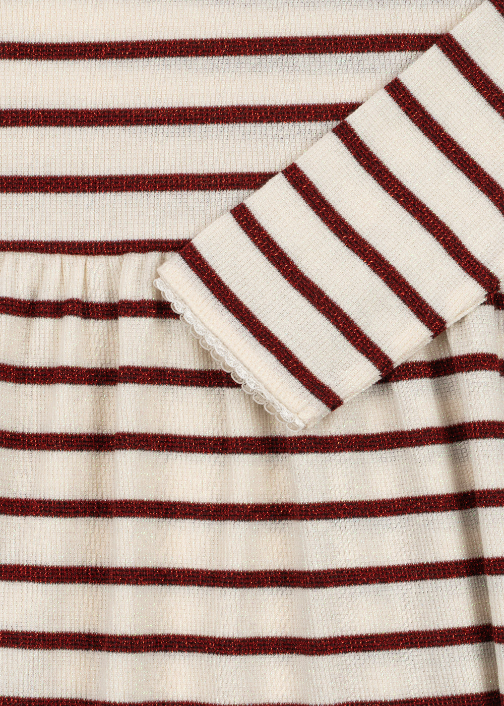 Close-up of a ribbed knit garment with horizontal burgundy and cream stripes, showing a folded cuff with a scalloped edge.