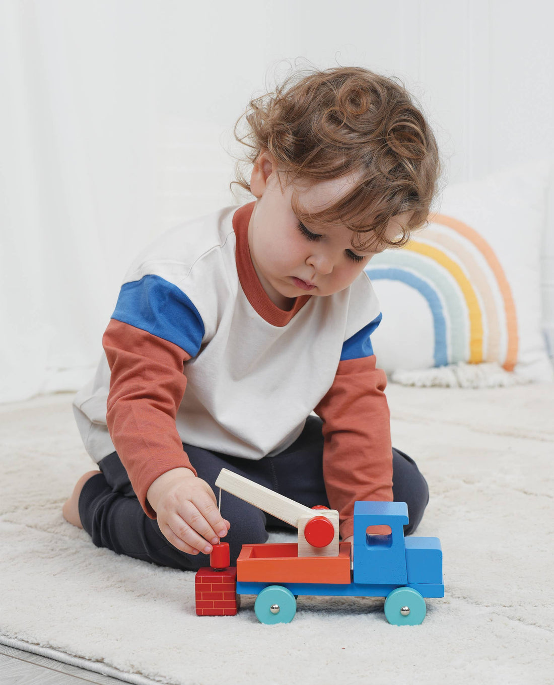 Baby boy playing with a Tender Leaf Wooden truck