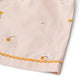 Close-up of delicate lace trim detail along the hem of the wheat-colored girls' shorts.
