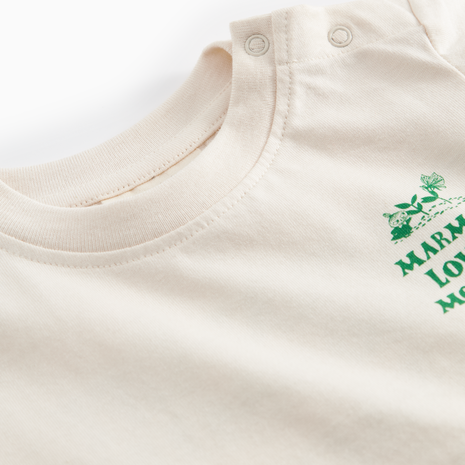 Beige baby onesie with green text on a white background