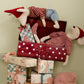 Stuffed toys in a suitcase with wrapped presents on a light green background