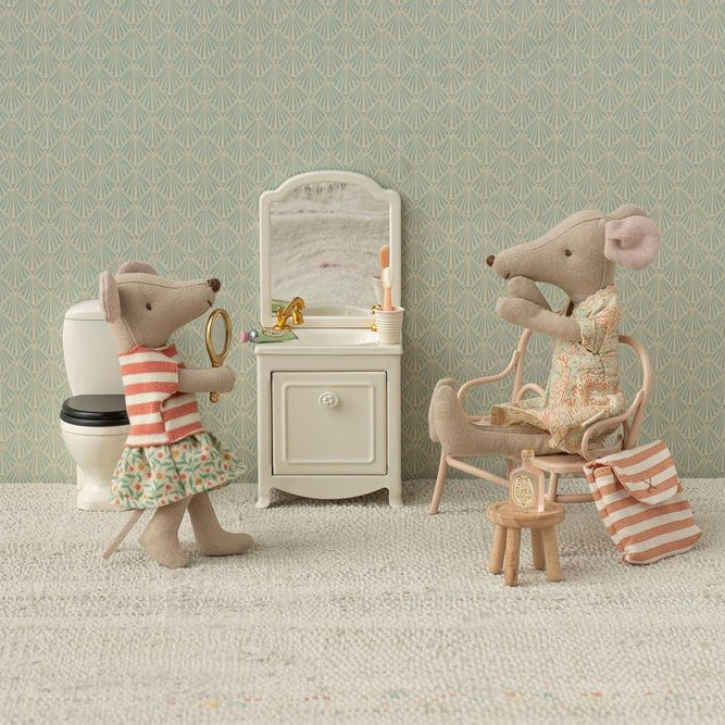 Two toy mice in a bathroom setting with a sink, mirror, and toilet.