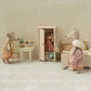 Miniature scene with toy mice in a room setting, including a wardrobe and furniture.