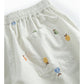 White shorts with colorful embroidered designs on a white background
