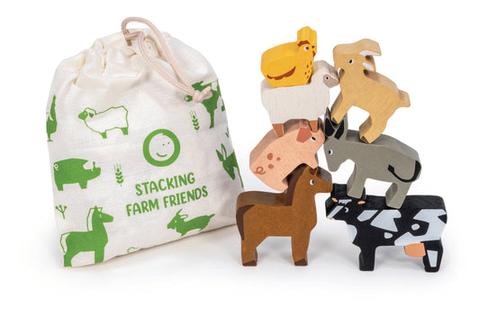 A children's stacking toy set featuring wooden farm animals and a matching fabric drawstring bag. The set includes a brown horse, black-and-white cow, gray donkey, pink pig, beige sheep, yellow chicken, tan goat, and a white goat, with the bag printed in green with the text 'STACKING FARM FRIENDS'.
