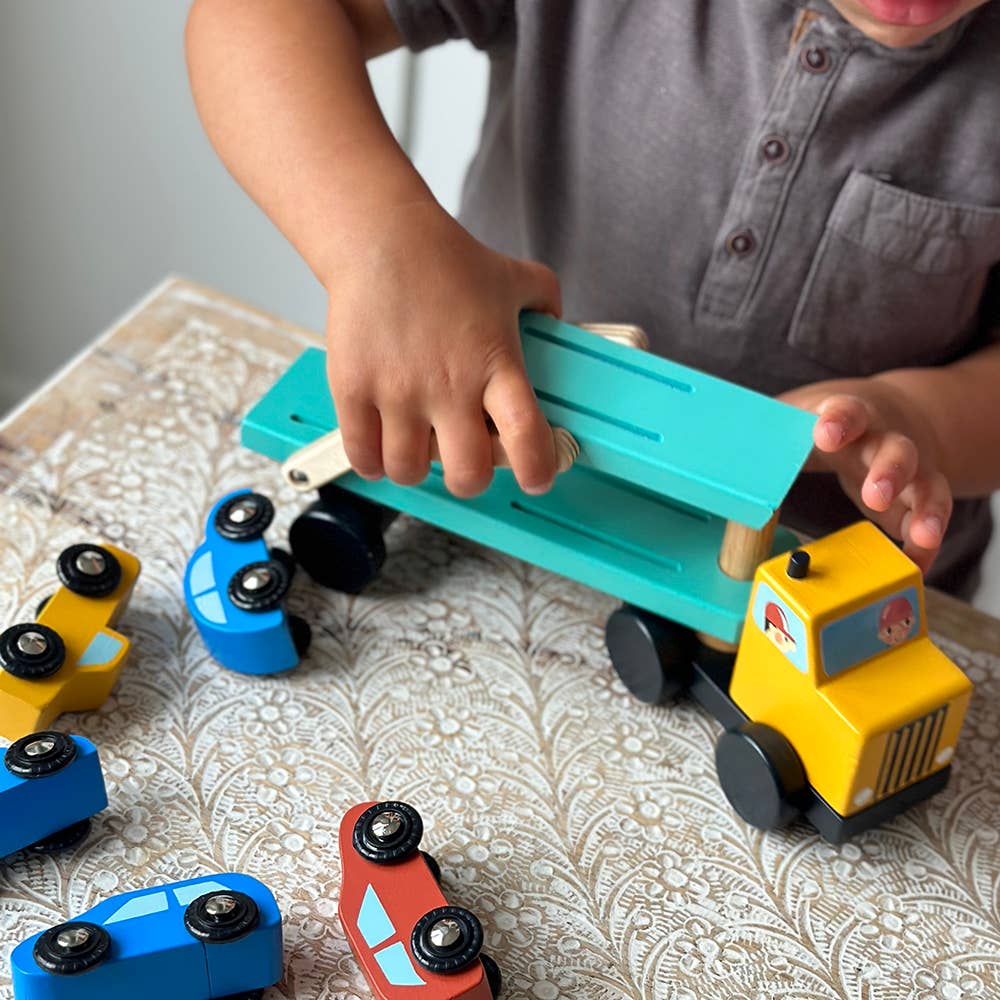 Child playing with toy cars on a patterned surface