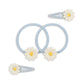 Set of hair ties and clips with daisy designs on a white background