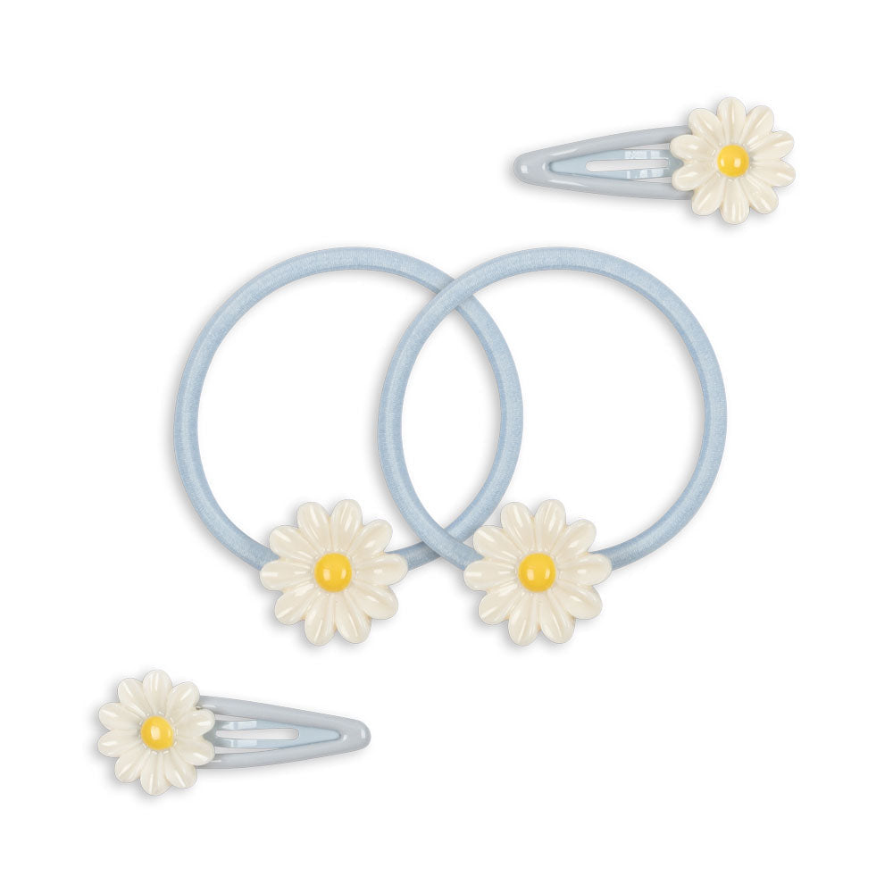 Set of hair ties and clips with daisy designs on a white background