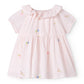Pink dress with floral embroidery on a white background