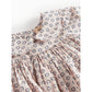 Floral patterned dress with a brand tag on a white background