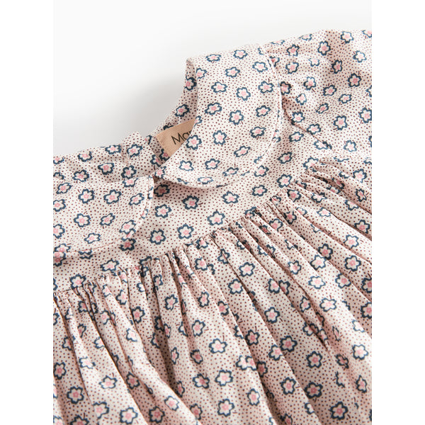 Floral patterned dress with a brand tag on a white background