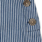 Close-up of a blue and white vertically striped fabric garment with two round bronze buttons, showing the texture of the woven material.