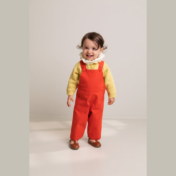 Baby girl wearing scarlet red Ruben dungaress from Marmar Copenhagen, soft cotton easy to wear.