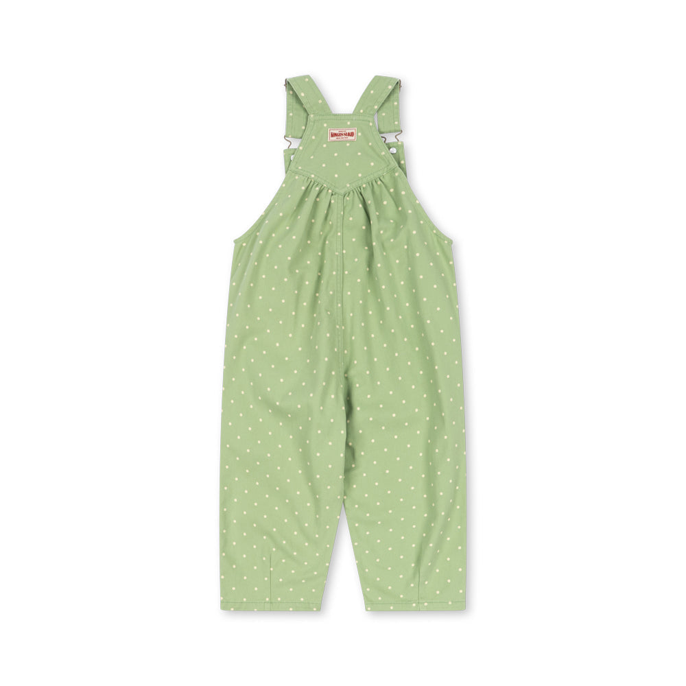 A light green baby overall jumpsuit with a white polka dot pattern, featuring adjustable shoulder straps and a smocked chest, shown flat on a white background.