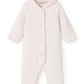 A light pink hooded baby jumpsuit with a tiny repeating floral pattern, featuring a snap-button front and long raglan sleeves, shown against a plain white background.