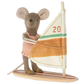 Stuffed toy mouse on a sailboat with a colorful sail.