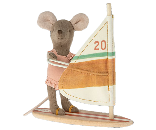 Stuffed toy mouse on a sailboat with a colorful sail.