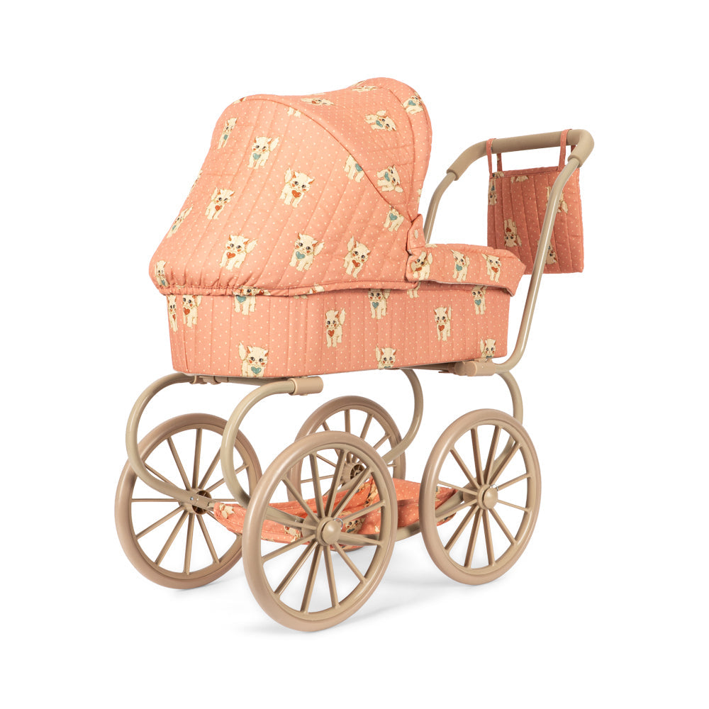 A vintage-style doll pram stroller with a peach-colored quilted fabric cover featuring a small teddy bear pattern, paired with a natural wood frame and four spoked wheels, shown on a plain white background.