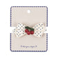 Polka dot bow hair clip with cherries on a branded card against a white background
