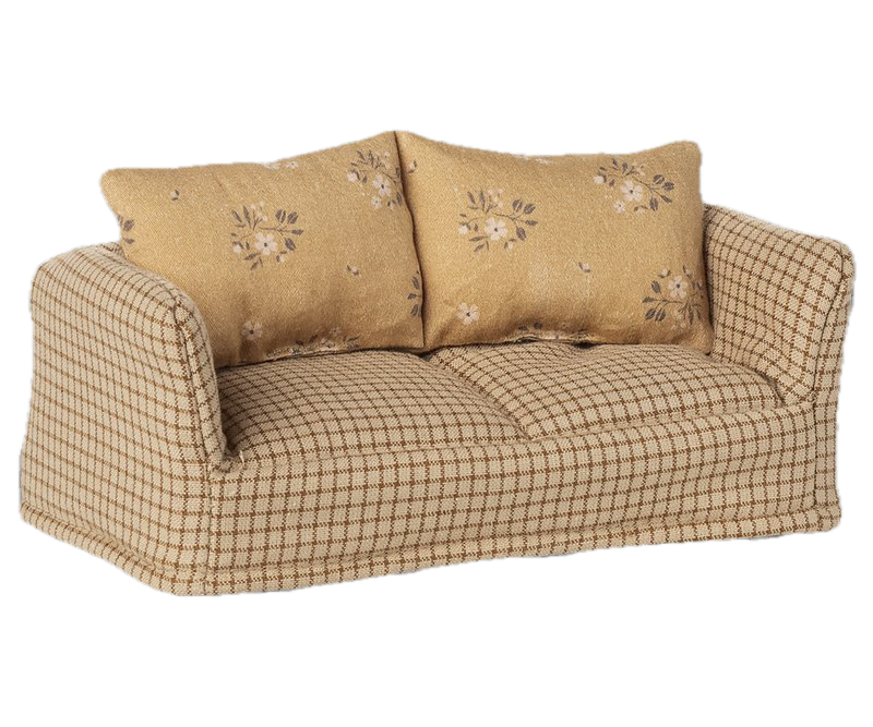 Sofa with checkered pattern and floral embroidered cushions on a white background