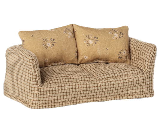 Sofa with checkered pattern and floral embroidered cushions on a white background
