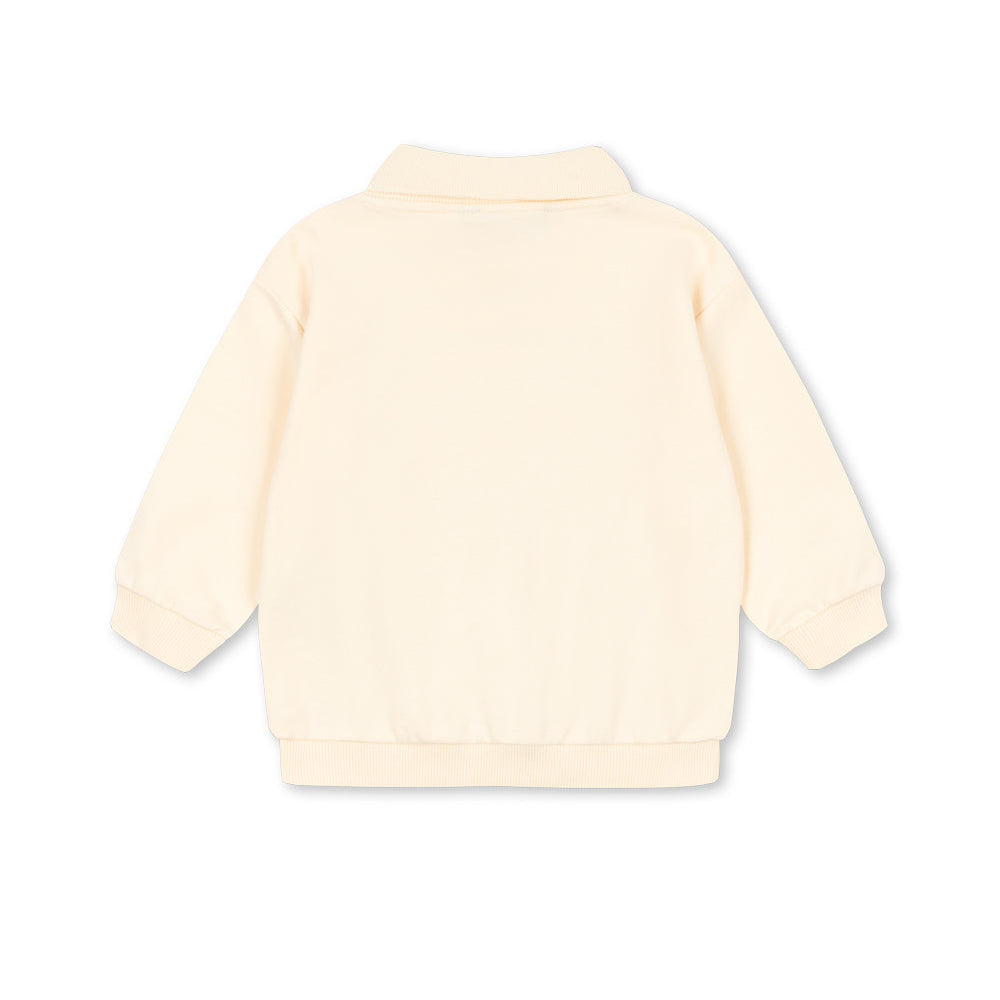 Back view of a light-colored sweater on a white background
