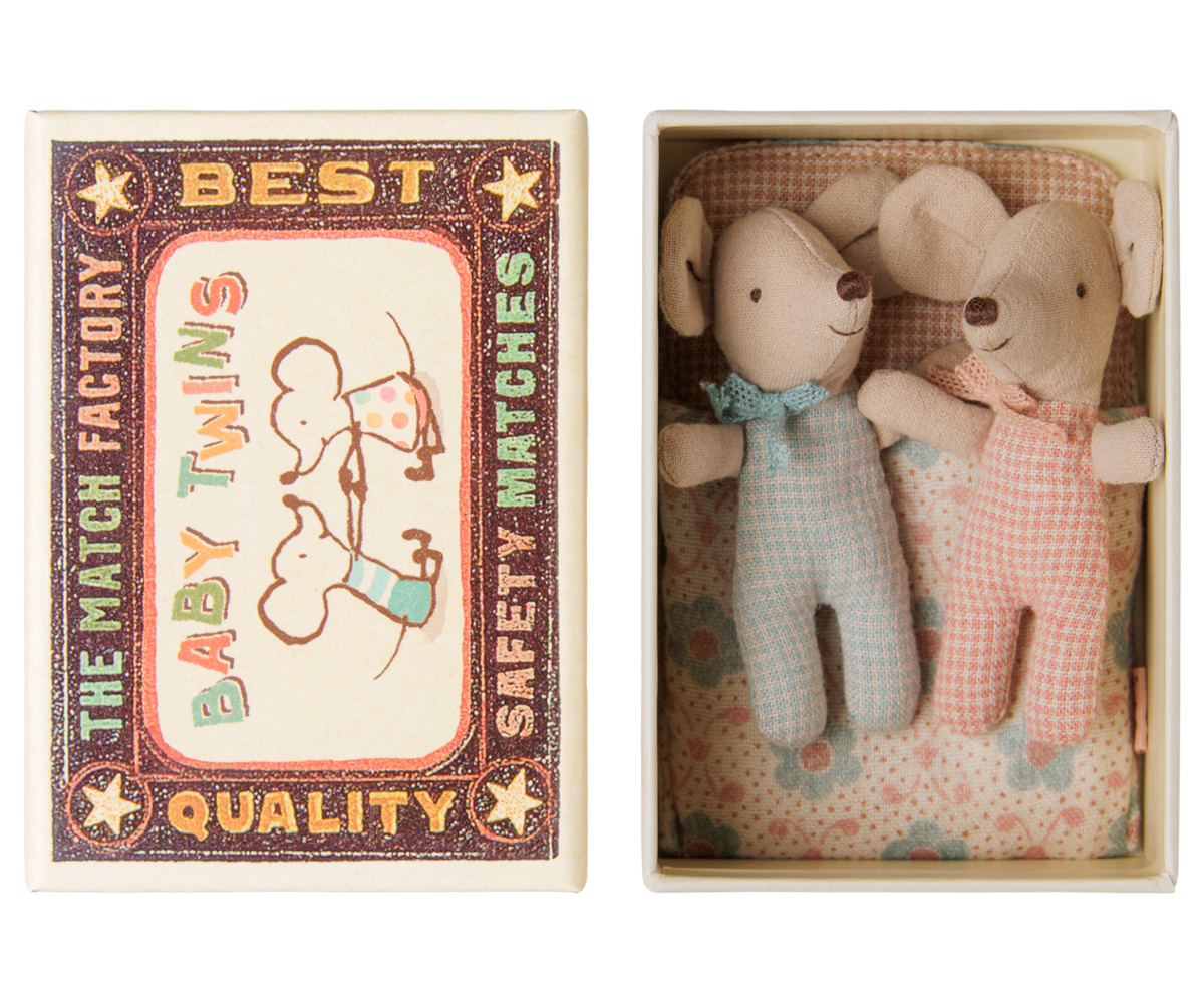 A matchbox-style gift set shown open, containing two small plush mouse toys dressed in light blue and pink gingham outfits with bow ties, alongside the illustrated matchbox lid.