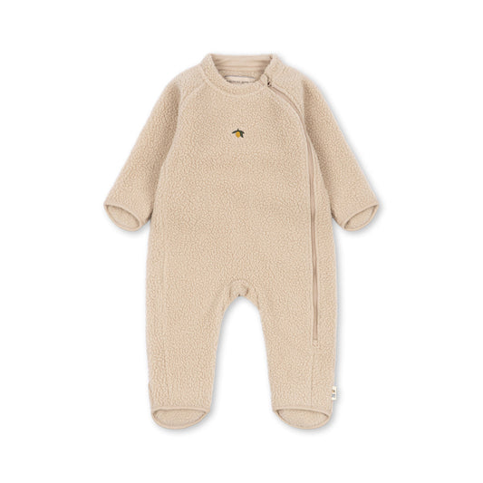 A baby's long-sleeve footed sleeper in a soft, textured beige fleece fabric, featuring a small embroidered animal logo on the left chest, displayed against a solid white background.