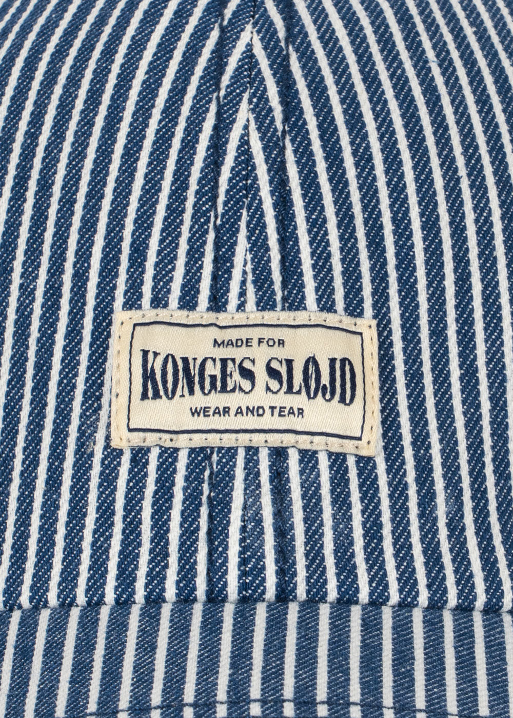 Close-up of a blue and white striped fabric with a 'Konges Slojd' label.
