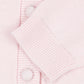 Close-up of a light pink knit cardigan with a ribbed button placket and matching buttons.
