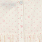 Close-up of a cream-colored dress with pink floral pattern and buttons.