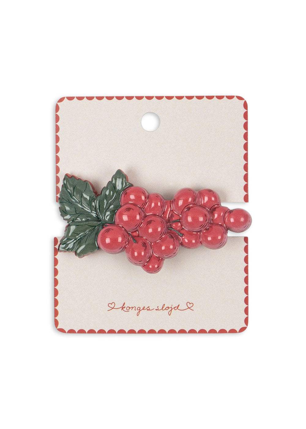 Red berry hair clip on a branded card with a white background