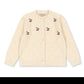 A cream-colored knit cardigan sweater with small embroidered cherry motifs on the front, displayed flat against a plain white background.