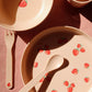 Children's tableware set with strawberry pattern on a pink surface