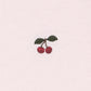 A close-up of a light pink textured fabric featuring a small embroidered motif of two red cherries with green leaves.