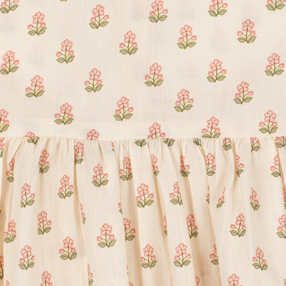 Floral patterned fabric with pink flowers and green leaves on a beige background