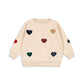 Beige sweater with colorful heart patterns on a white background