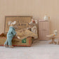 Two toy mice in a miniature room setting with a cardboard box, table, and cabinet.