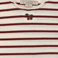 Close-up of a striped knit top with horizontal burgundy and cream stripes, a small embroidered cherry motif at the center chest, and a visible neck label reading KONGES SLAVID.