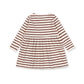 A long-sleeve baby dress with horizontal rust red and cream stripes, shown from the back on a solid white background.