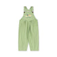 A light green children's overall jumpsuit with white polka dots, featuring adjustable shoulder straps with small brown buttons and a colorful cartoon graphic on the chest, displayed against a solid white background.