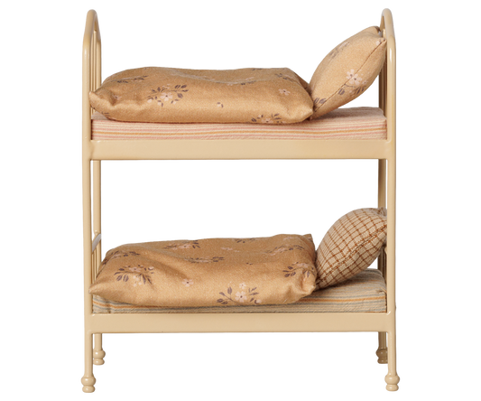 A miniature two-tier dollhouse bed frame with cream-colored metal rails and upholstered cushions in beige and brown floral patterns, shown against a plain white background.
